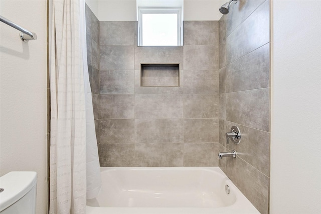 bathroom featuring shower / bath combo and toilet