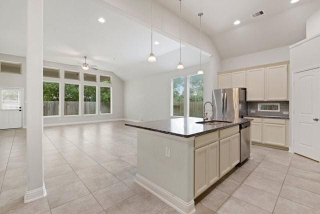 kitchen featuring hanging light fixtures, an island with sink, stainless steel appliances, and lofted ceiling