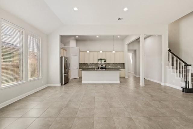 unfurnished living room with light tile patterned floors and lofted ceiling