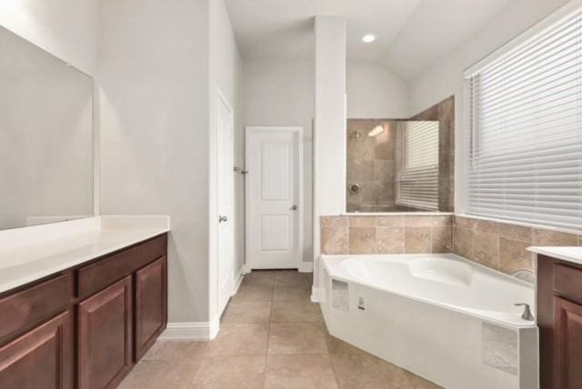 bathroom with separate shower and tub, tile patterned flooring, vanity, and lofted ceiling