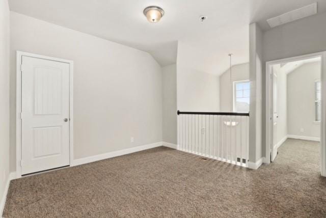 spare room with dark carpet and lofted ceiling