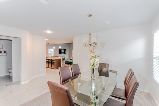 dining space with a notable chandelier and sink