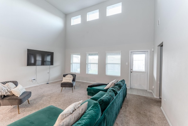 living room with a towering ceiling, carpet floors, and a healthy amount of sunlight