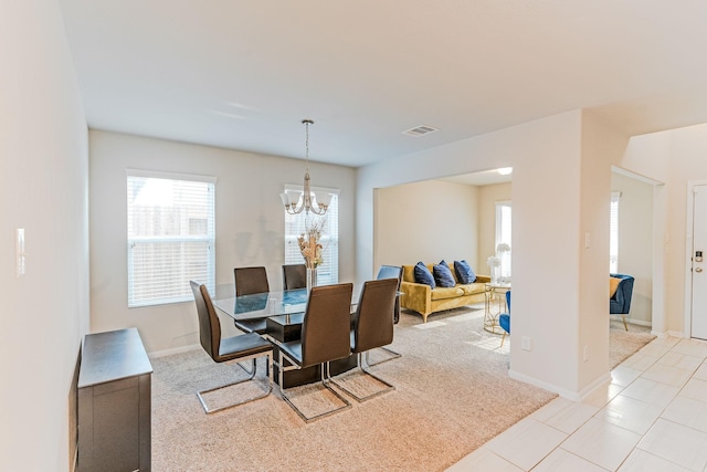 tiled dining area featuring an inviting chandelier