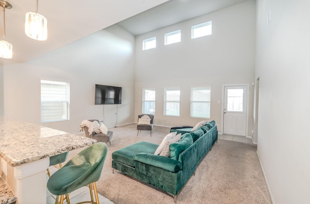 living room featuring plenty of natural light, light carpet, and a high ceiling