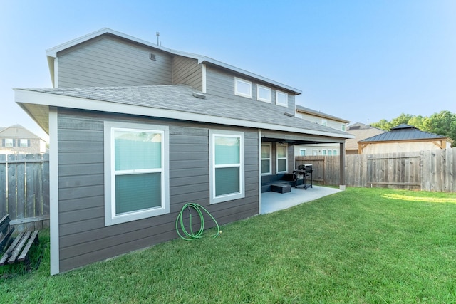 rear view of property featuring a patio area and a lawn