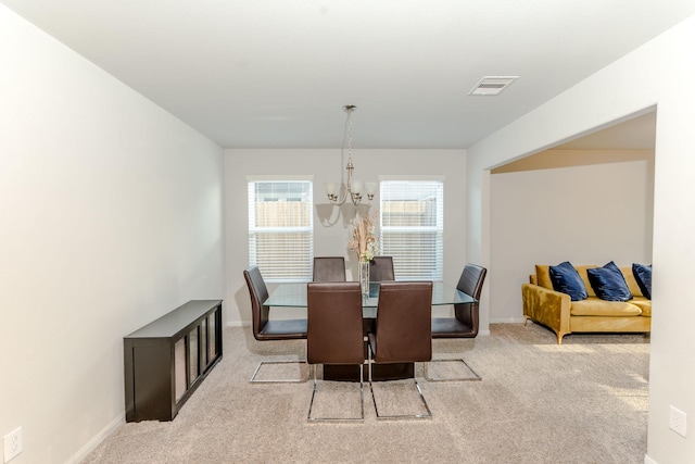 carpeted dining space featuring a chandelier