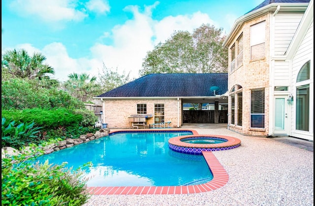 view of swimming pool featuring an in ground hot tub and a patio