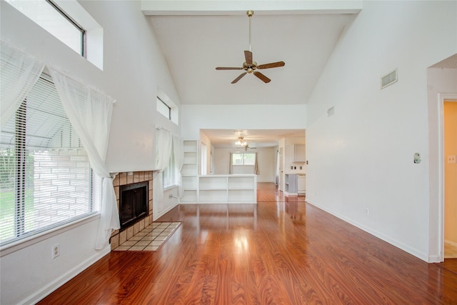 unfurnished living room with ceiling fan, a fireplace, high vaulted ceiling, and hardwood / wood-style flooring