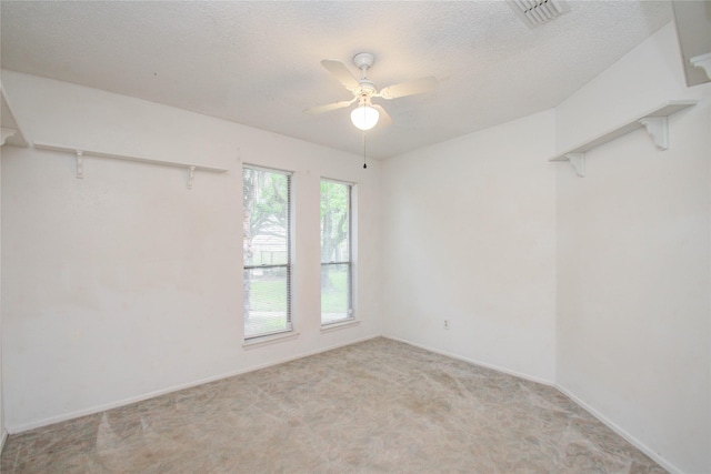 carpeted empty room featuring a textured ceiling and ceiling fan