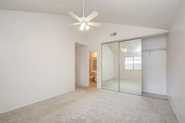 unfurnished bedroom featuring ceiling fan, carpet floors, connected bathroom, and a closet