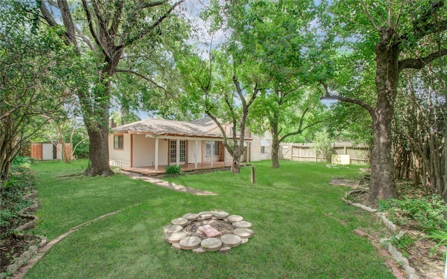 view of yard with a storage shed, an outdoor fire pit, and french doors