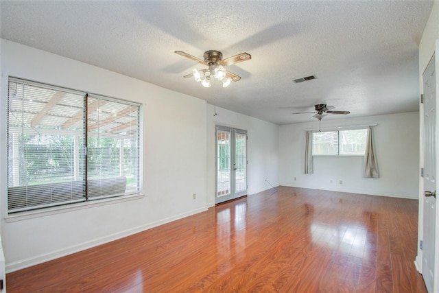 unfurnished room featuring ceiling fan, wood-type flooring, and a textured ceiling