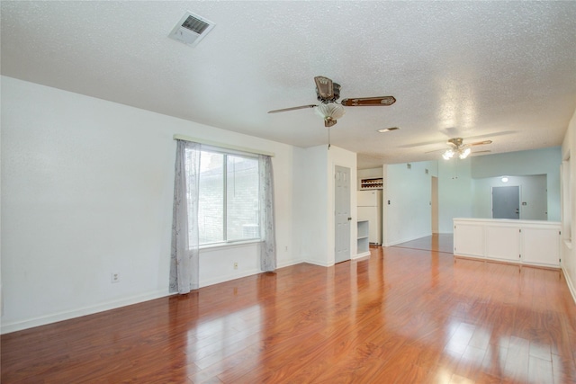 spare room with ceiling fan, light hardwood / wood-style floors, and a textured ceiling