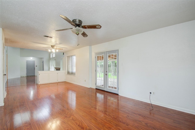 unfurnished living room featuring french doors, a textured ceiling, light hardwood / wood-style floors, and ceiling fan