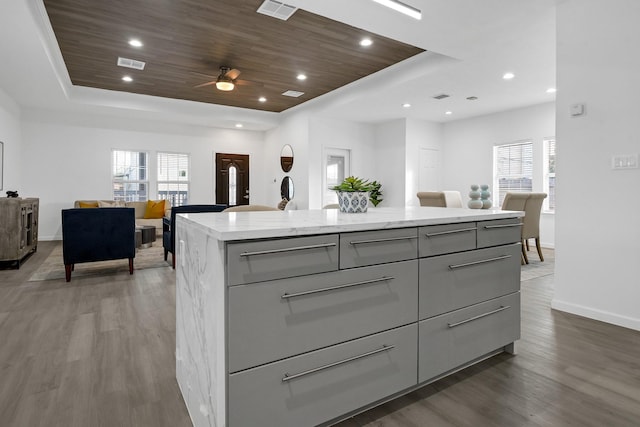 kitchen with a center island, gray cabinets, and dark wood-type flooring