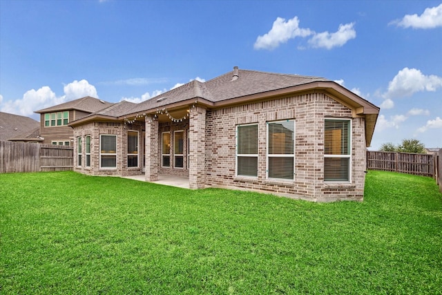 back of house with a patio area and a lawn