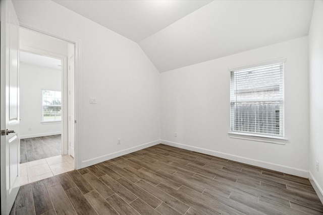 spare room featuring lofted ceiling and hardwood / wood-style flooring