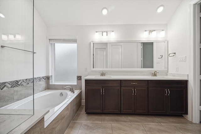 bathroom with tile patterned floors, vanity, and a relaxing tiled tub