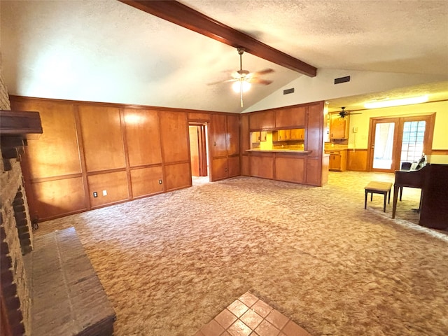 unfurnished living room with lofted ceiling with beams, light colored carpet, a textured ceiling, and a brick fireplace