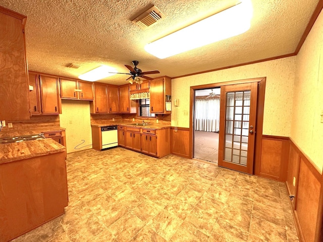 kitchen featuring sink, white dishwasher, a textured ceiling, and ornamental molding