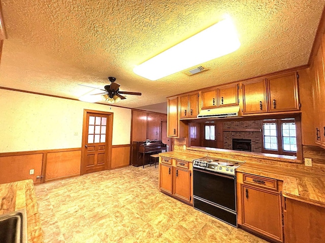 kitchen featuring a textured ceiling, plenty of natural light, range with electric cooktop, and exhaust hood