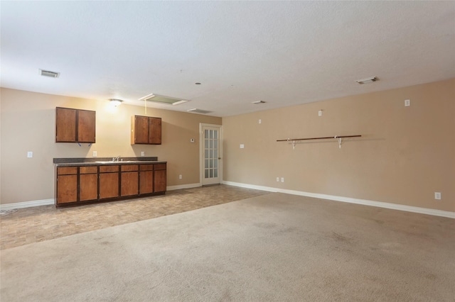 unfurnished living room featuring a textured ceiling and light colored carpet