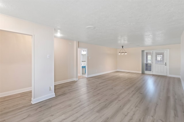 interior space with a textured ceiling and light hardwood / wood-style floors