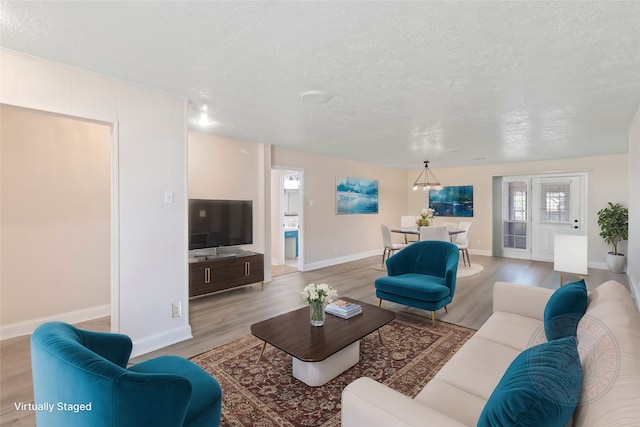 living room featuring light wood-type flooring and a textured ceiling