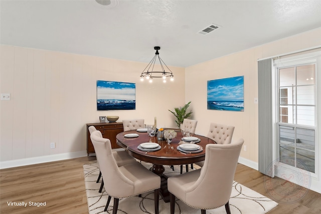 dining room featuring an inviting chandelier and light hardwood / wood-style flooring