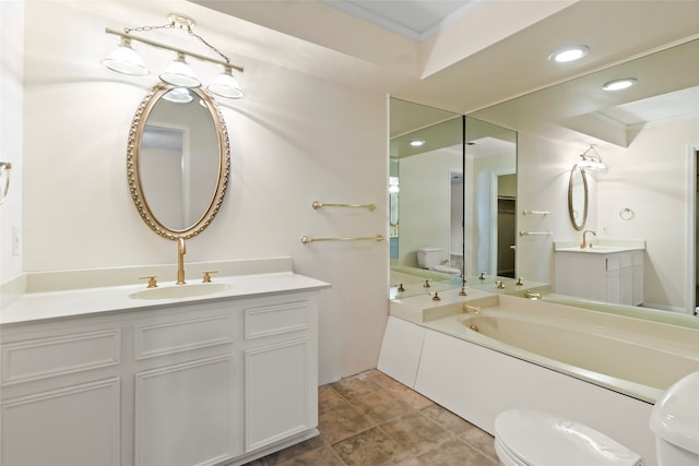 bathroom with toilet, vanity, ornamental molding, and a bath