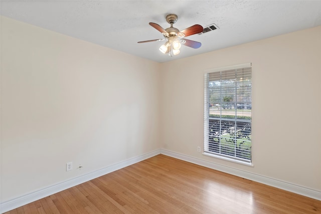 empty room with light hardwood / wood-style floors, a textured ceiling, and ceiling fan