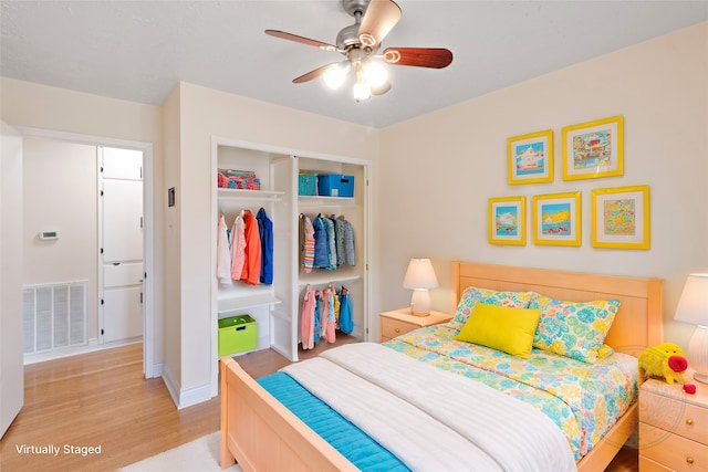 bedroom featuring ceiling fan, a closet, and light hardwood / wood-style flooring