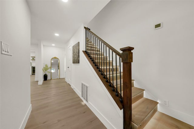 staircase with hardwood / wood-style flooring