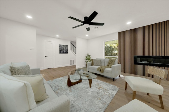 living room with light wood-type flooring and ceiling fan