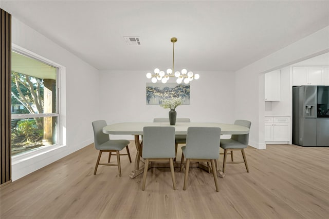 dining area with a chandelier and light hardwood / wood-style floors