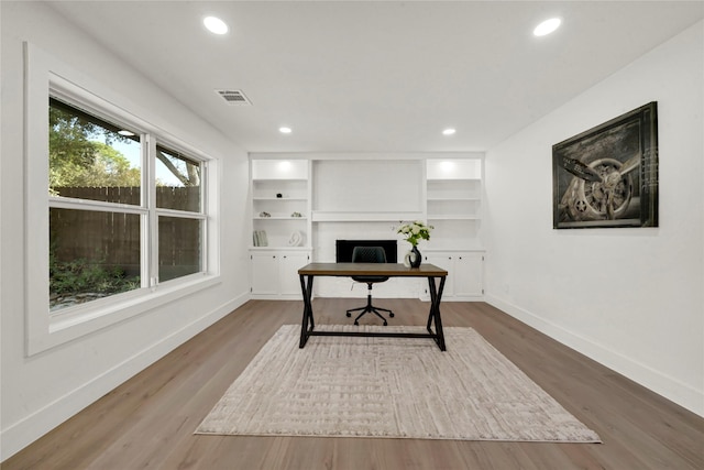 office featuring built in features and wood-type flooring