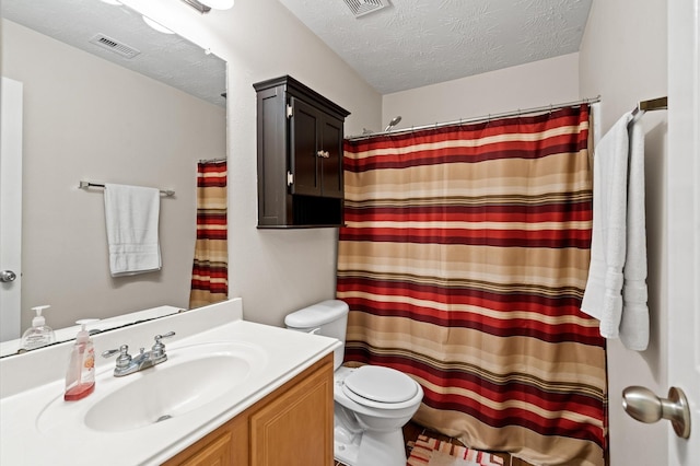 bathroom with vanity, toilet, a textured ceiling, and walk in shower