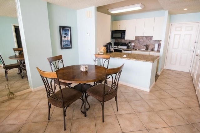 dining room with light tile patterned flooring, a textured ceiling, and sink