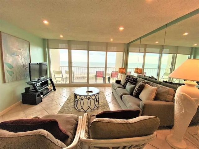 tiled living room with a textured ceiling and a water view