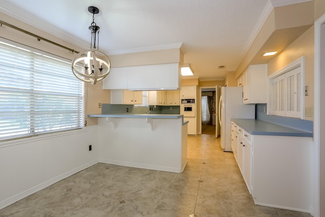 kitchen featuring white cabinetry, a notable chandelier, pendant lighting, white appliances, and ornamental molding