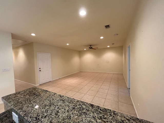 empty room with ceiling fan and light tile patterned floors