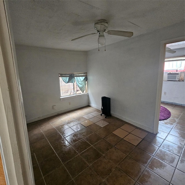 spare room with cooling unit, ceiling fan, plenty of natural light, and dark tile patterned floors