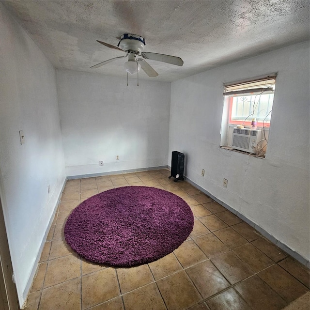 spare room featuring ceiling fan, cooling unit, and a textured ceiling