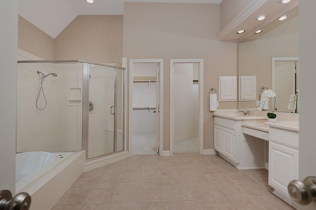 full bathroom featuring vanity, a stall shower, tile patterned flooring, vaulted ceiling, and a spacious closet