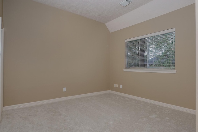 carpeted empty room with lofted ceiling, baseboards, visible vents, and a textured ceiling