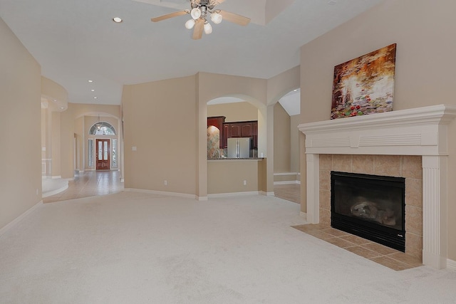 unfurnished living room with recessed lighting, baseboards, light colored carpet, and a fireplace