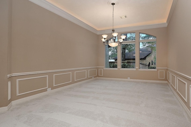 unfurnished room with carpet, an inviting chandelier, ornamental molding, and a decorative wall