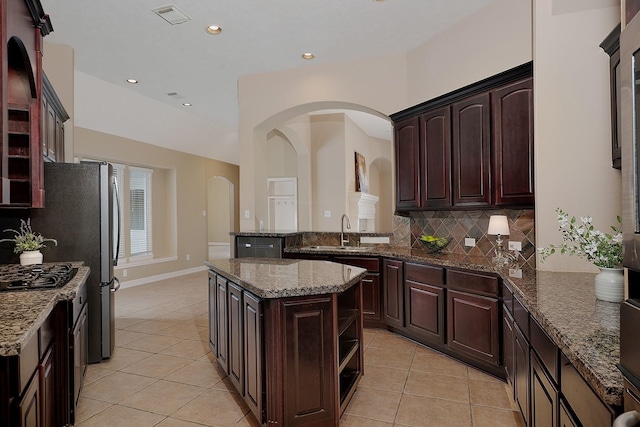 kitchen with visible vents, open shelves, light tile patterned flooring, a sink, and decorative backsplash