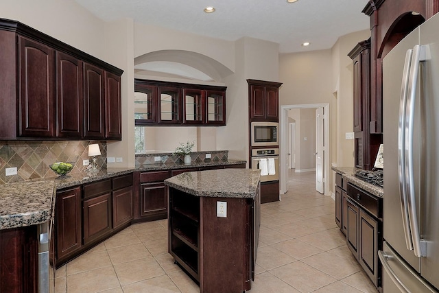 kitchen with light tile patterned flooring, decorative backsplash, stainless steel appliances, and open shelves